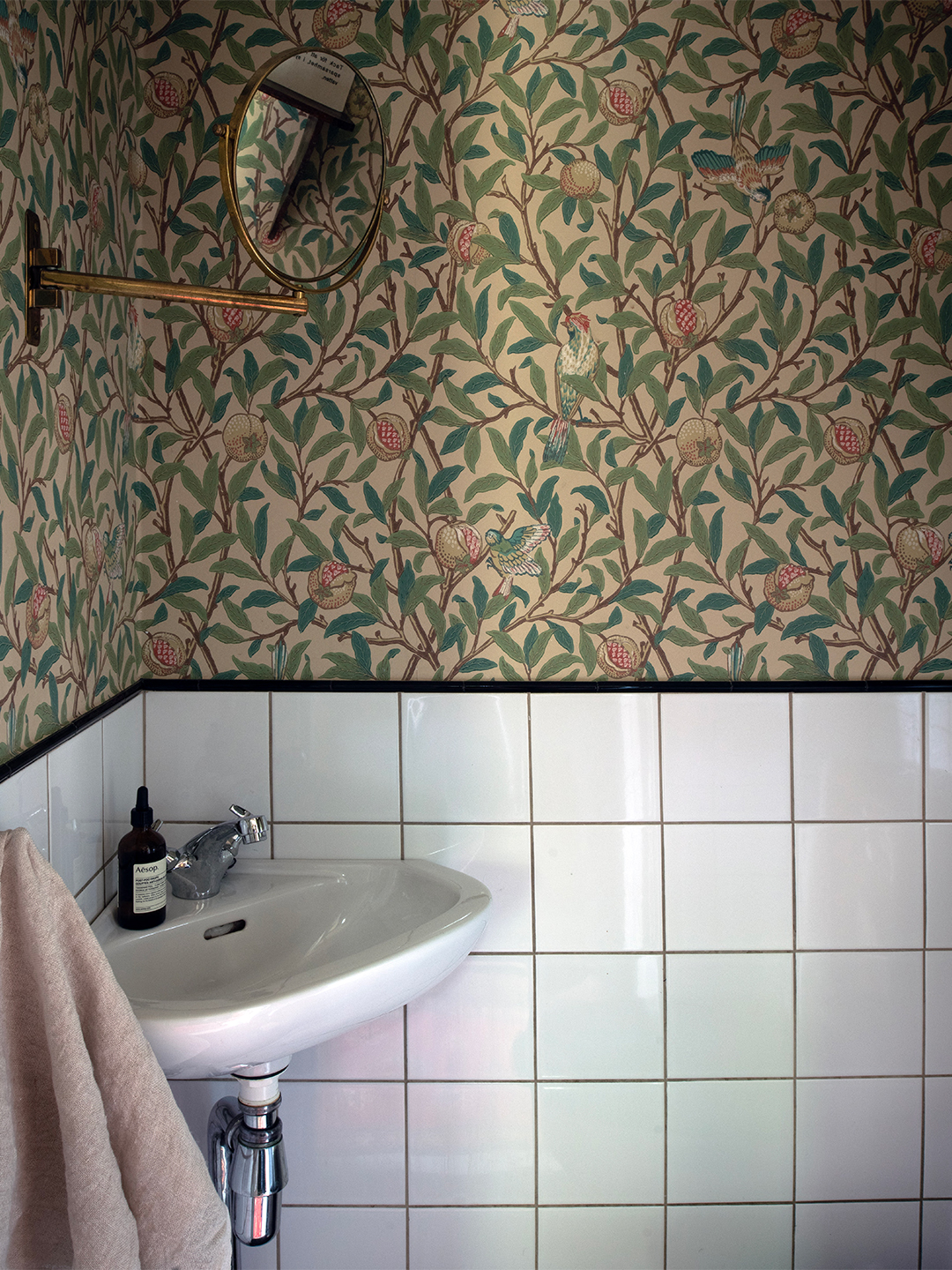 bathroom with wallpapered wall and tiles