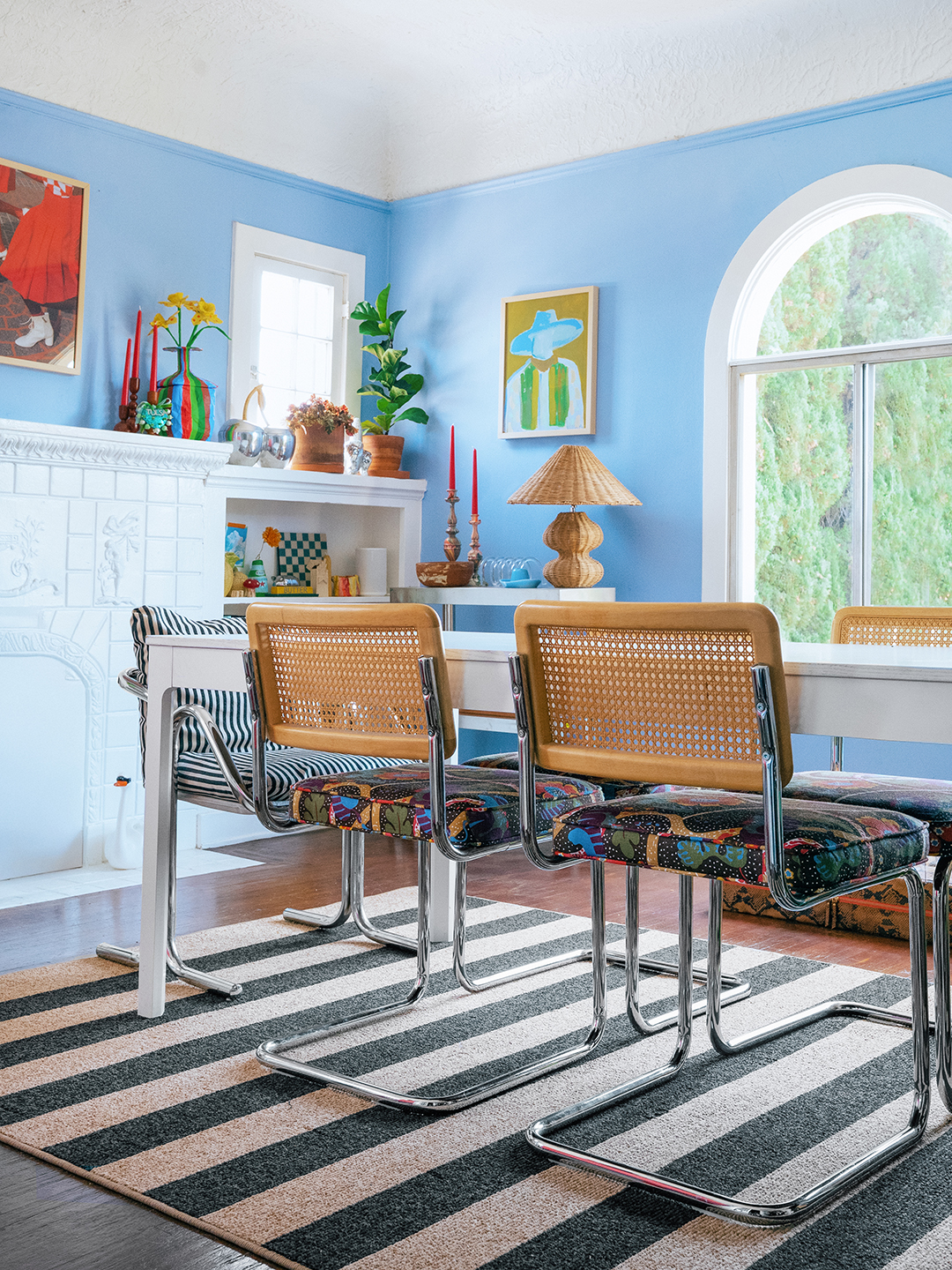 Light blue dining room with black and brown striped jute rug. 