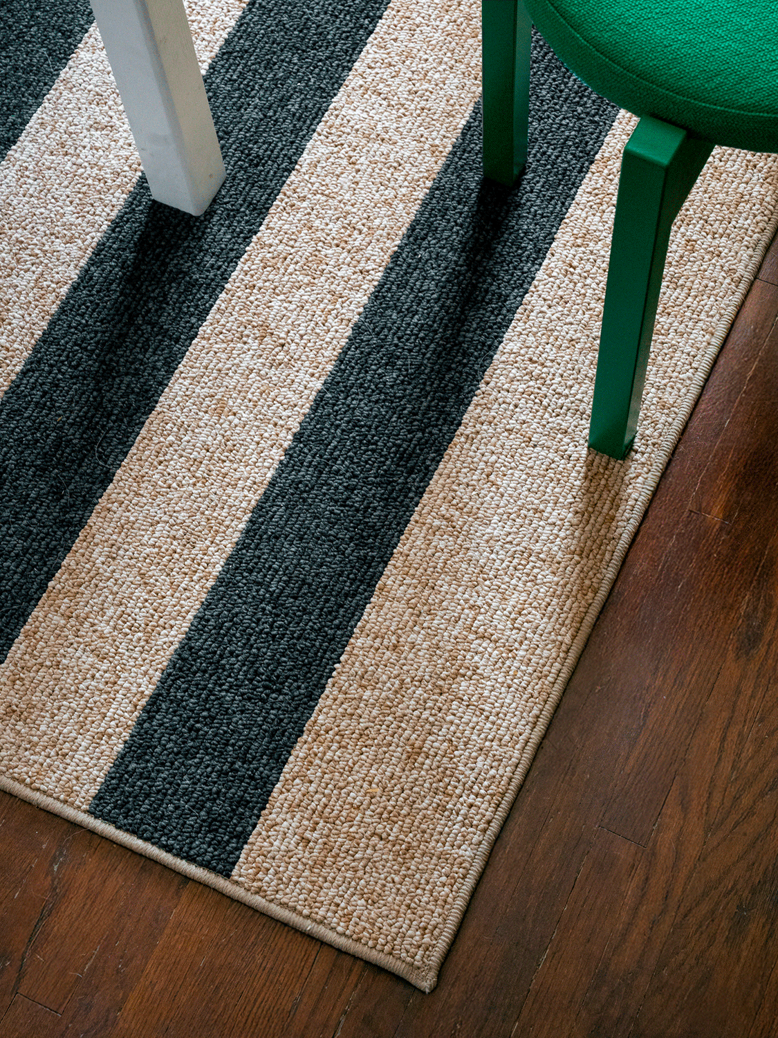 Gif of popcorn falling on black and brown striped jute rug. 