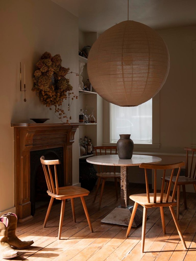 round dining table and wood chairs with large round pendant