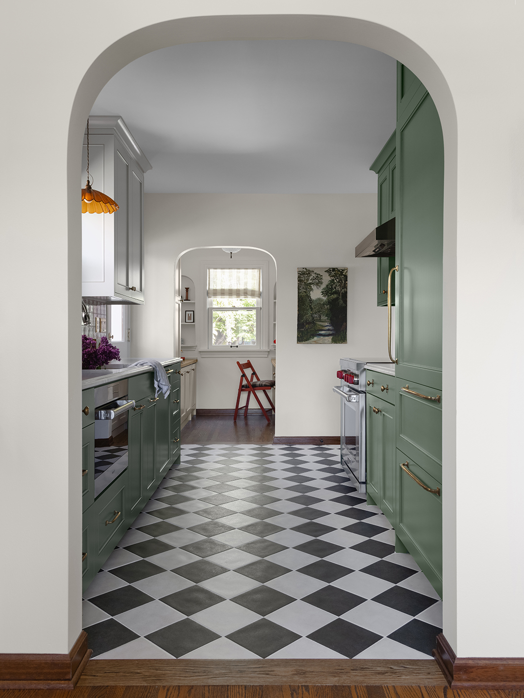 archway leading to green galley kitchen