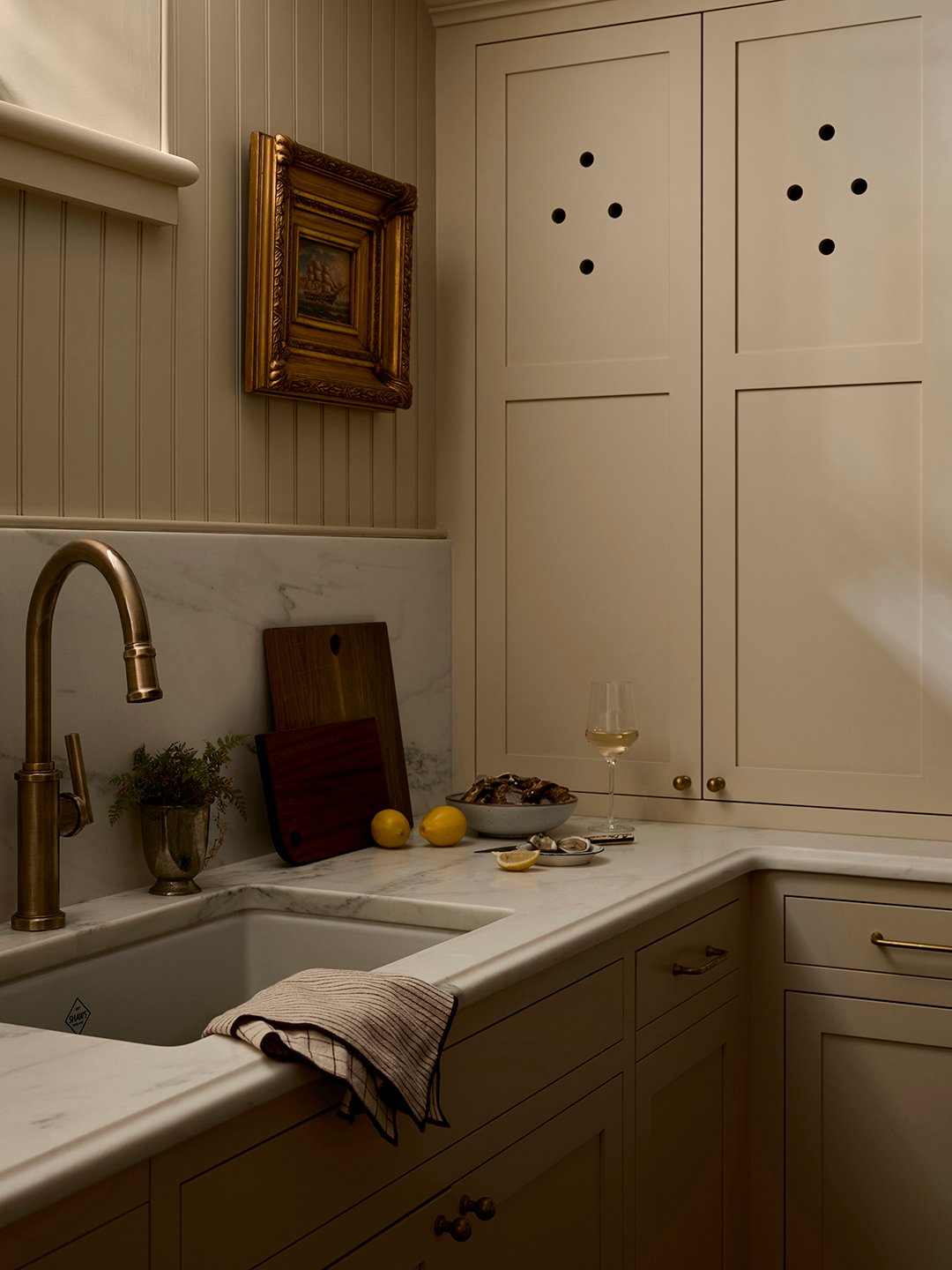 cream kitchen with marble counters and backsplash