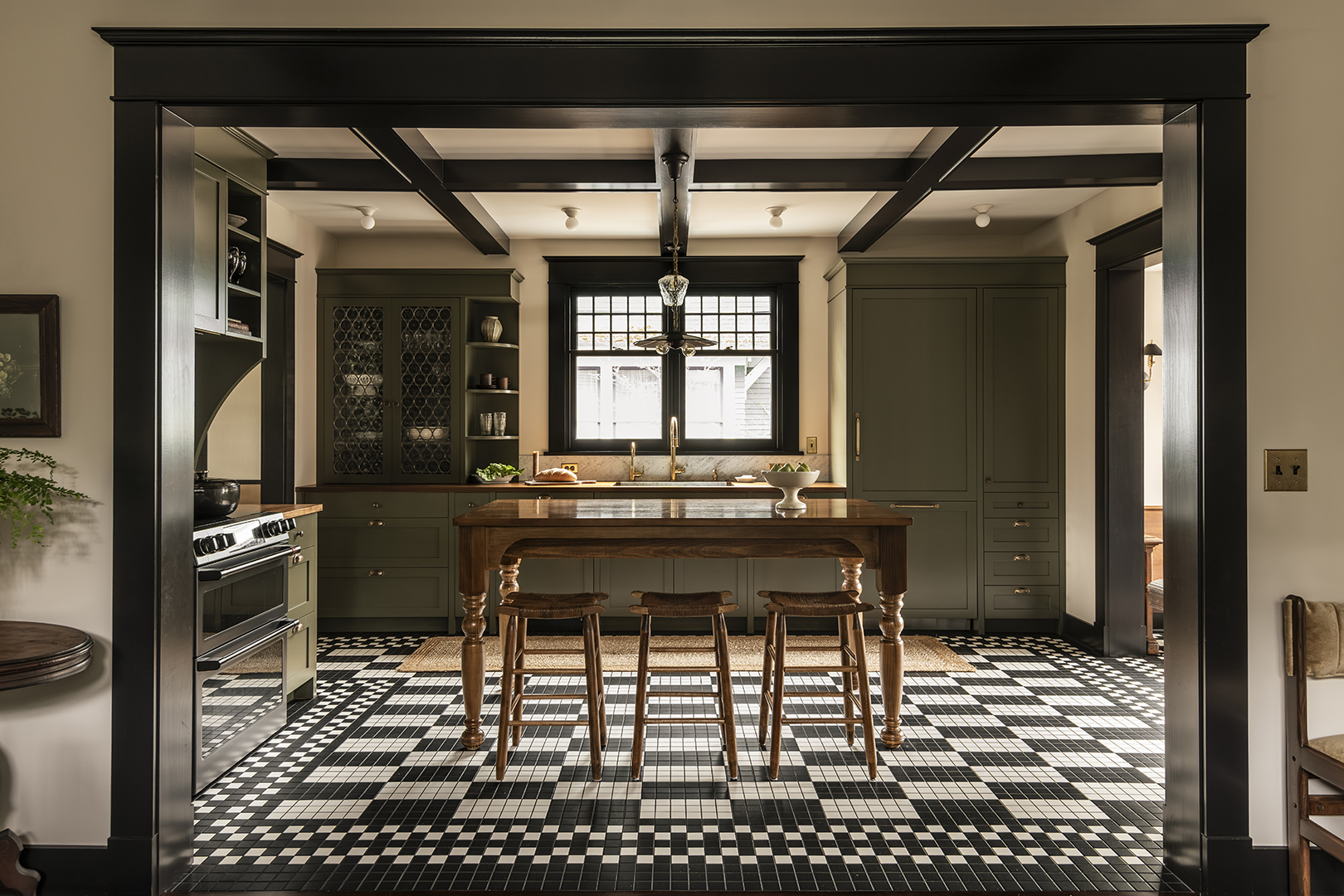 green kitchen with black and white floor tile