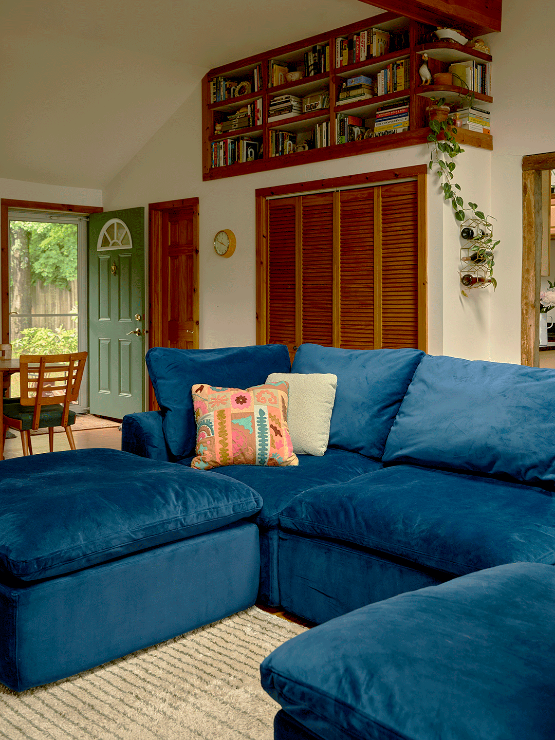 Blue velvet sofa gif coming together and apart in a living room to show functionality. 