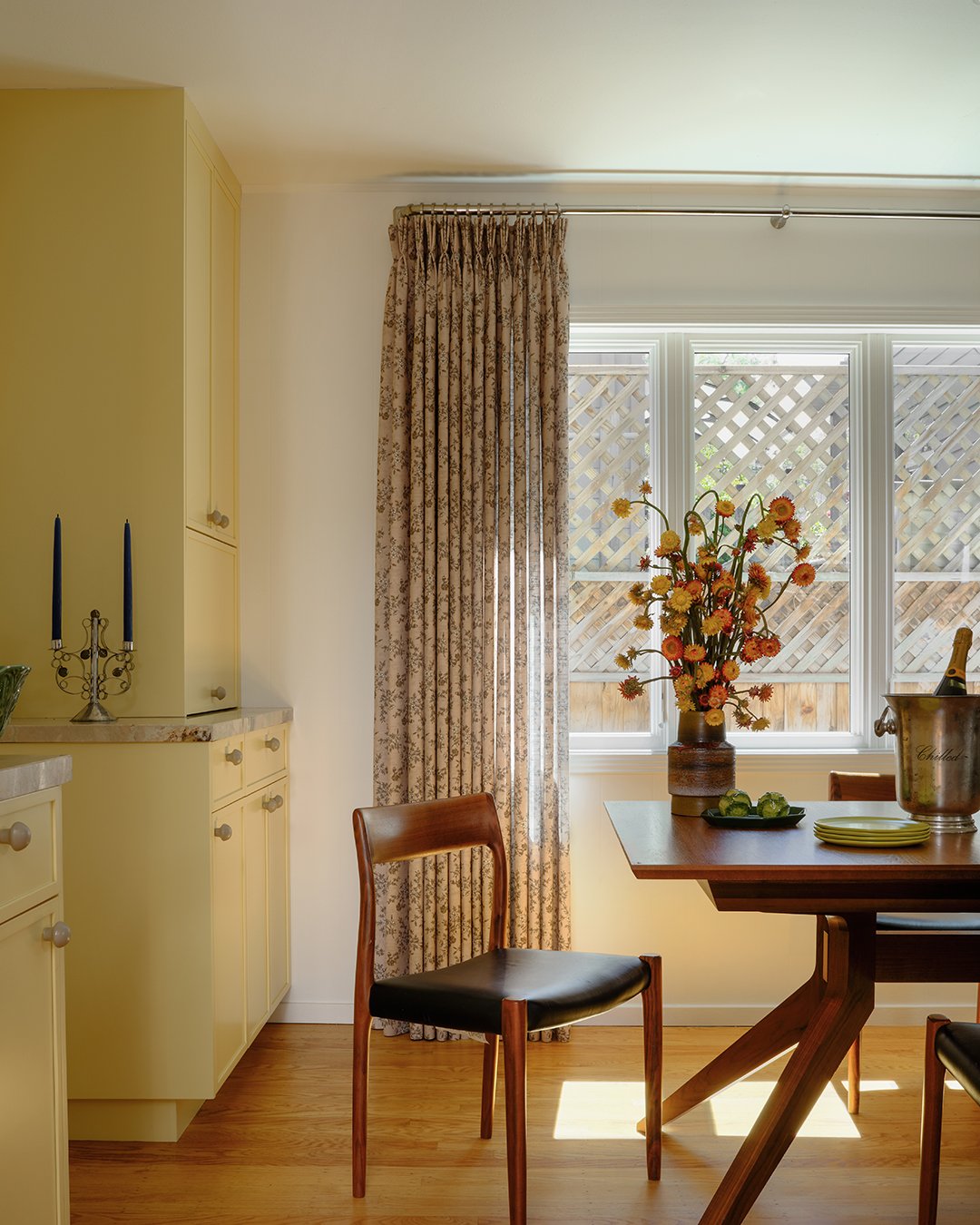 dining table next to yellow cabinets