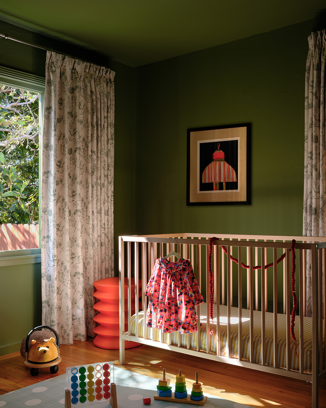 green bedroom with wood crib