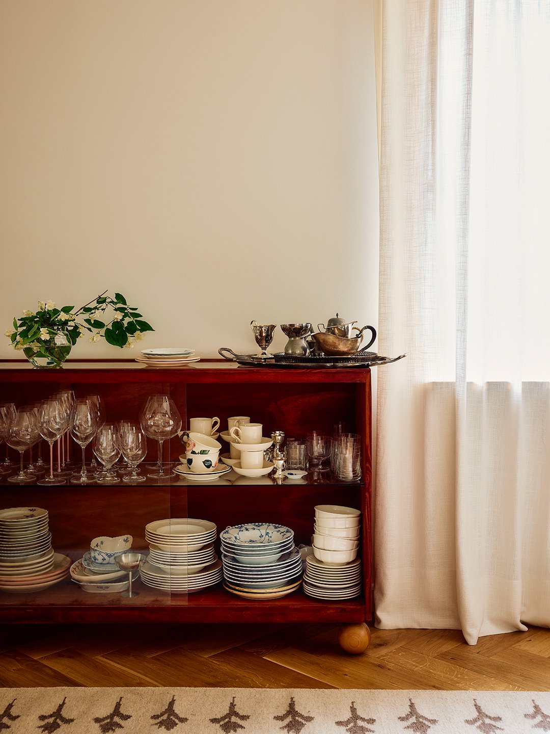 low red bookshelf stocked with glassware