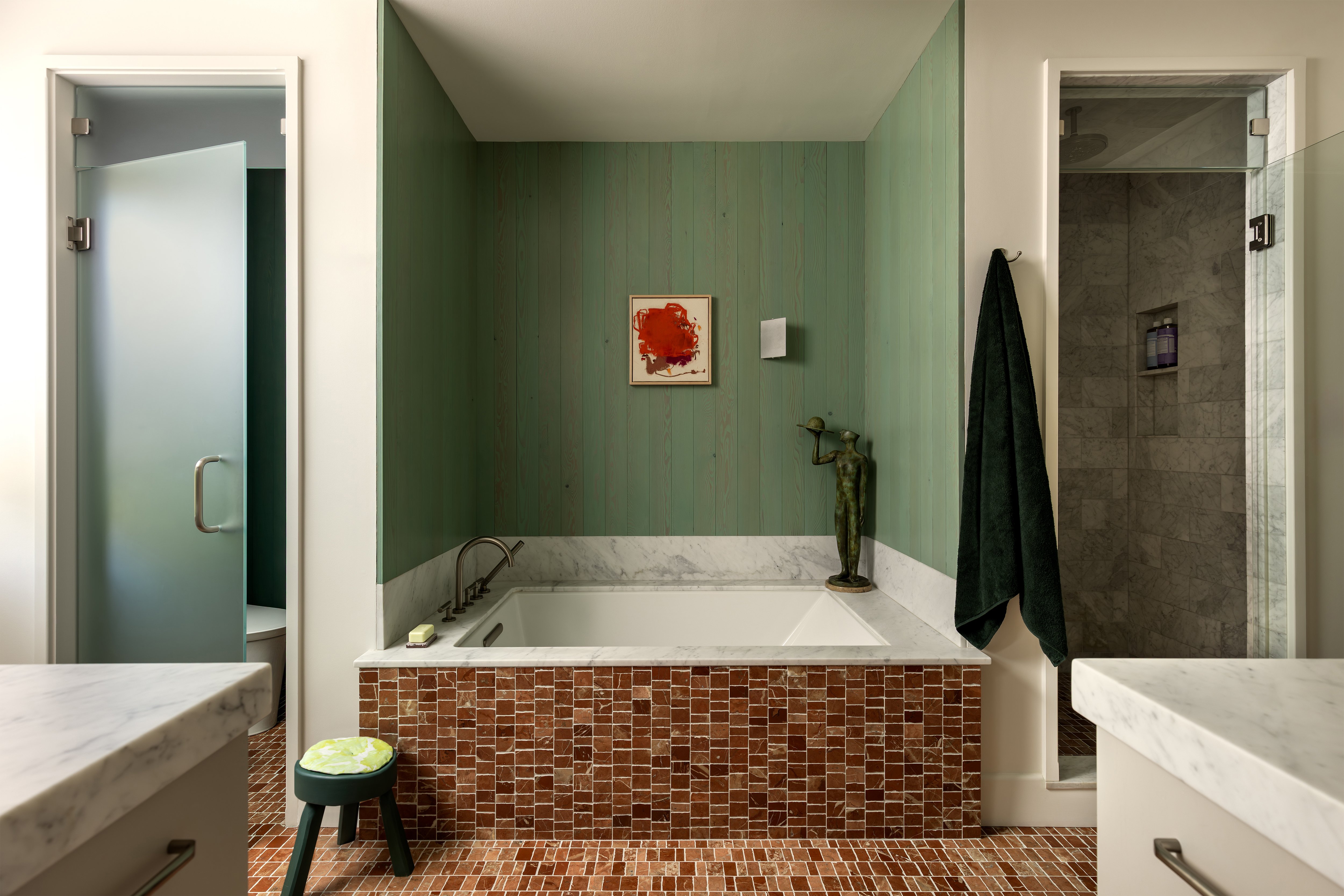 bathtub with reddish brown marble tile surround