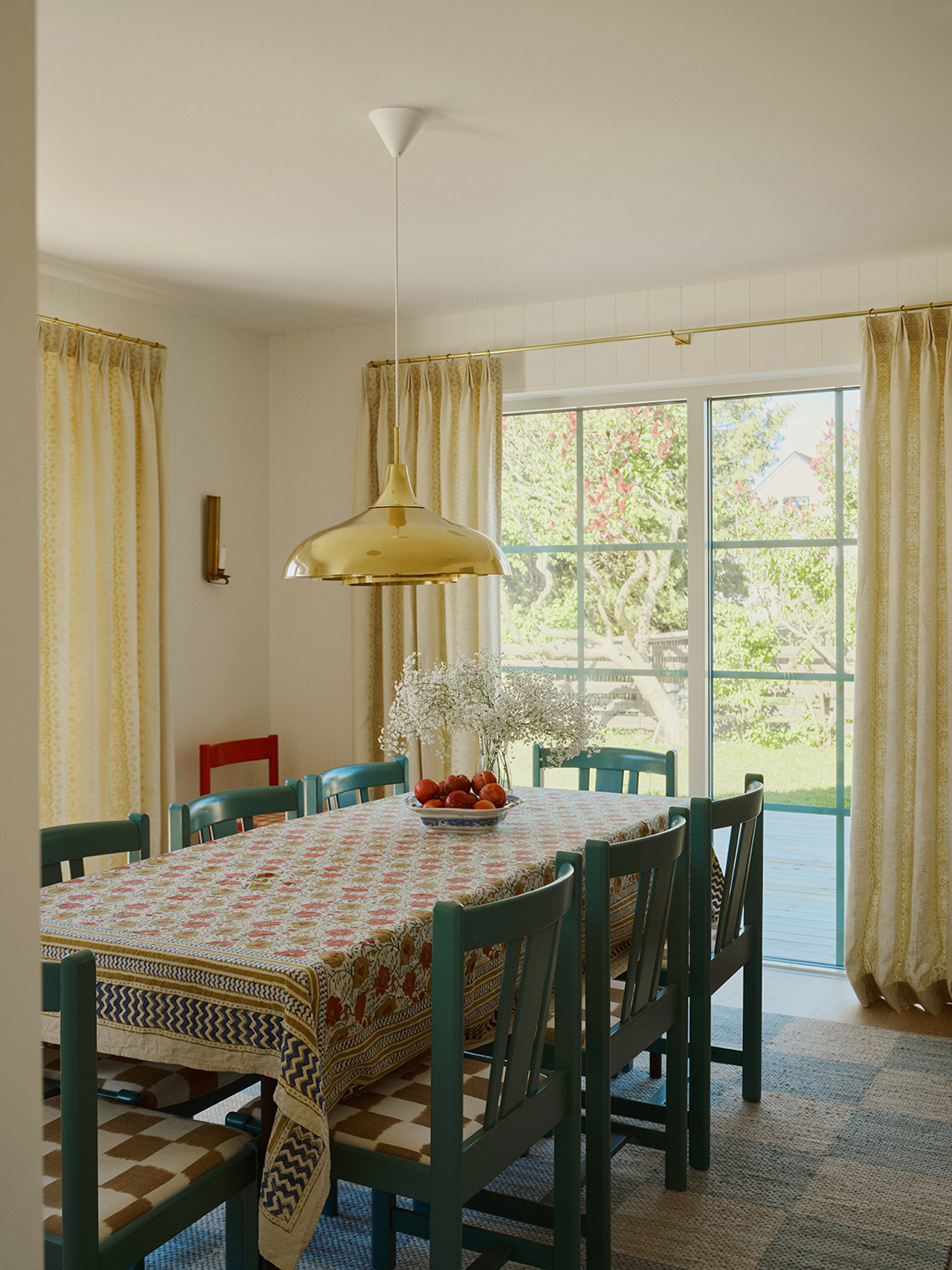 dining room with teal chairs and gold pendant