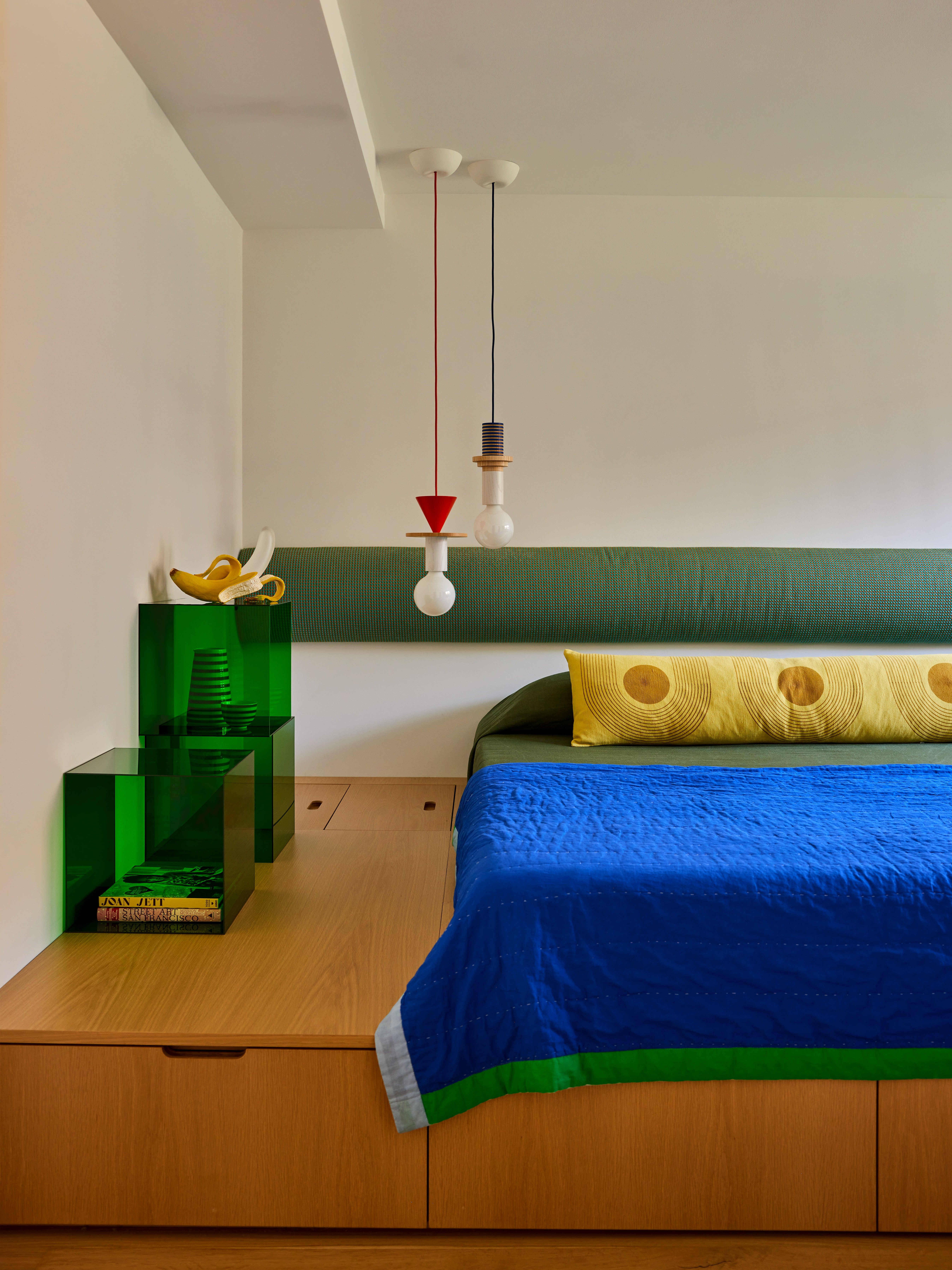 bright blue bed with yellow lumbar pillow