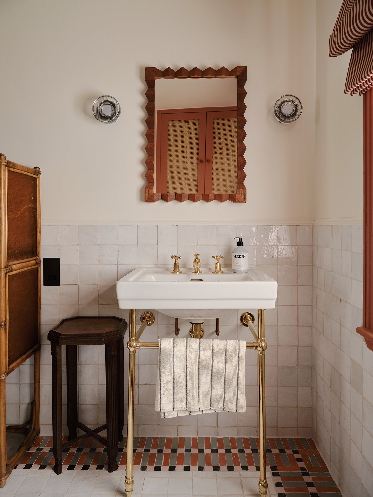 white bathroom with colorful tile floor border