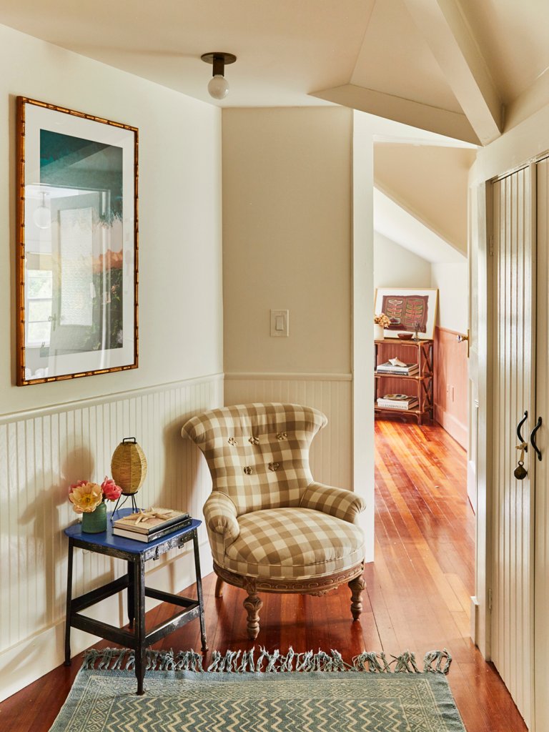 plaid chair and navy stool in corner of room