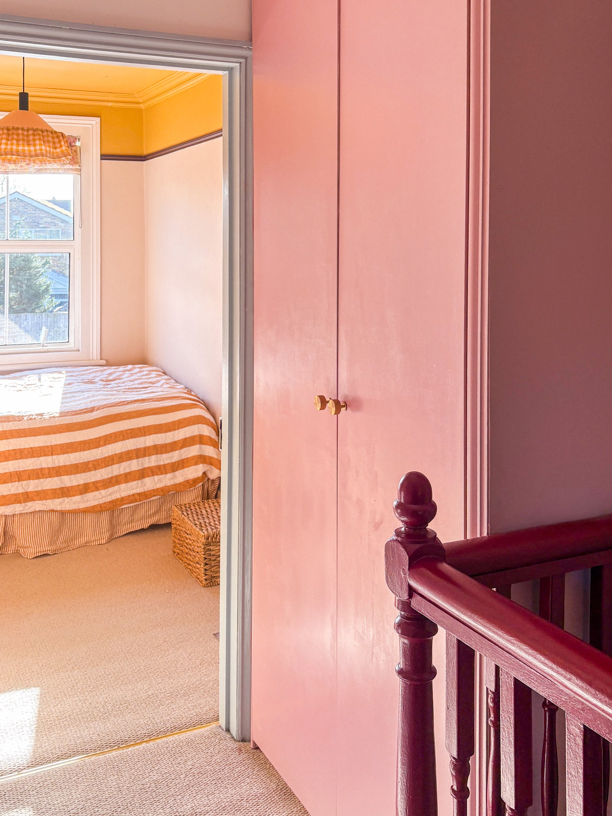pink cabinet in a sunny hallway