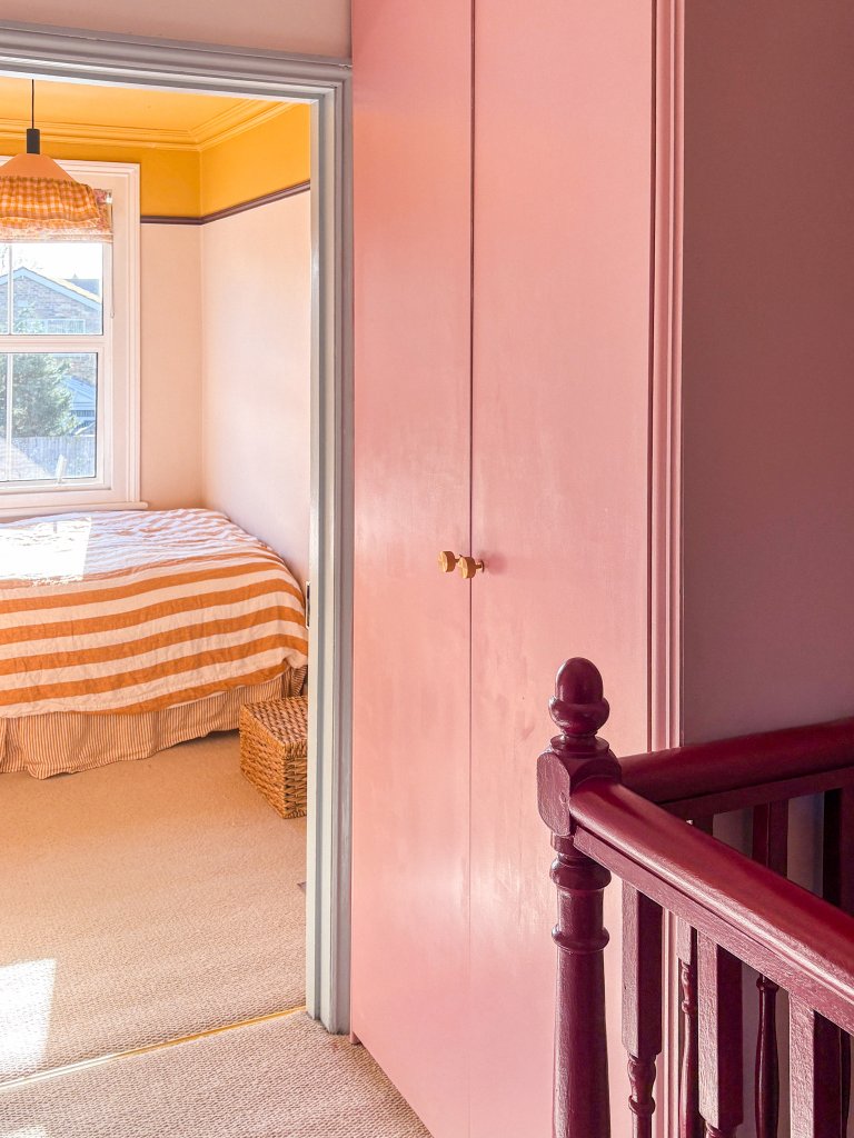 pink cabinet in a sunny hallway