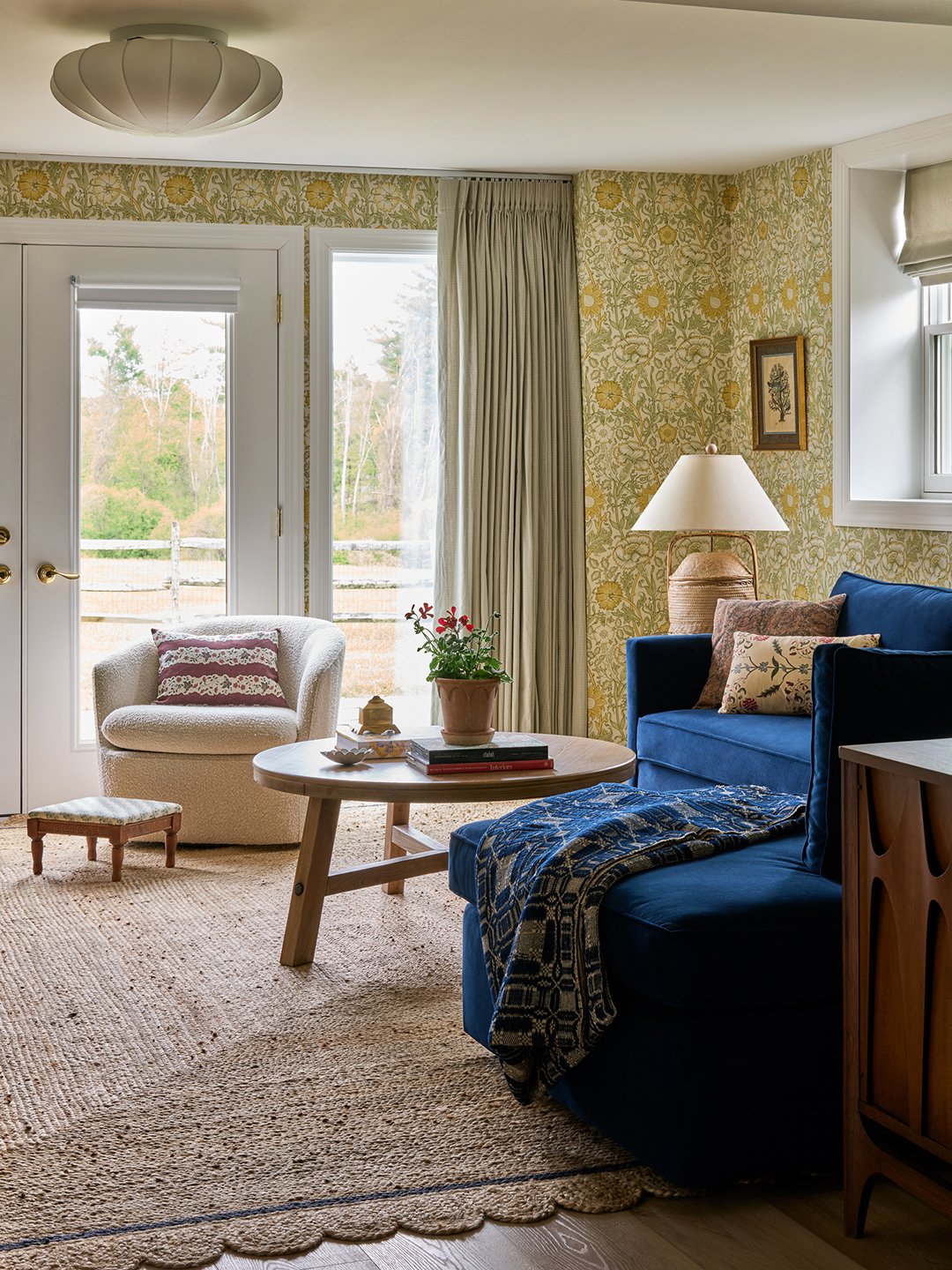 living area with wallpaper and blue sofa