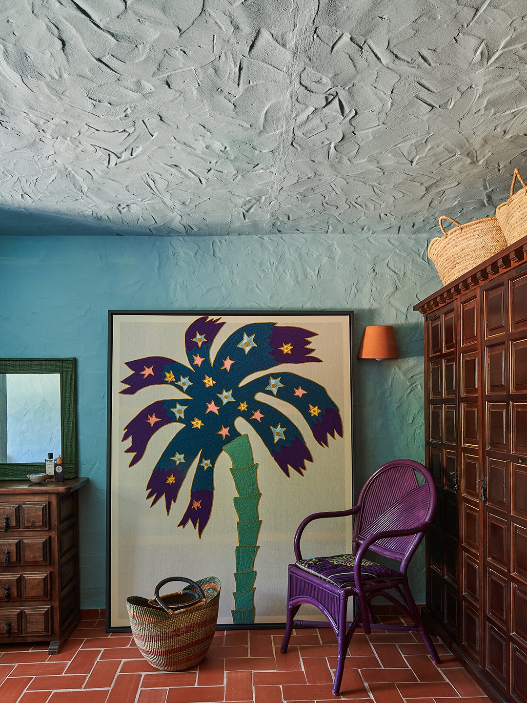 blue room with a framed palm tree print