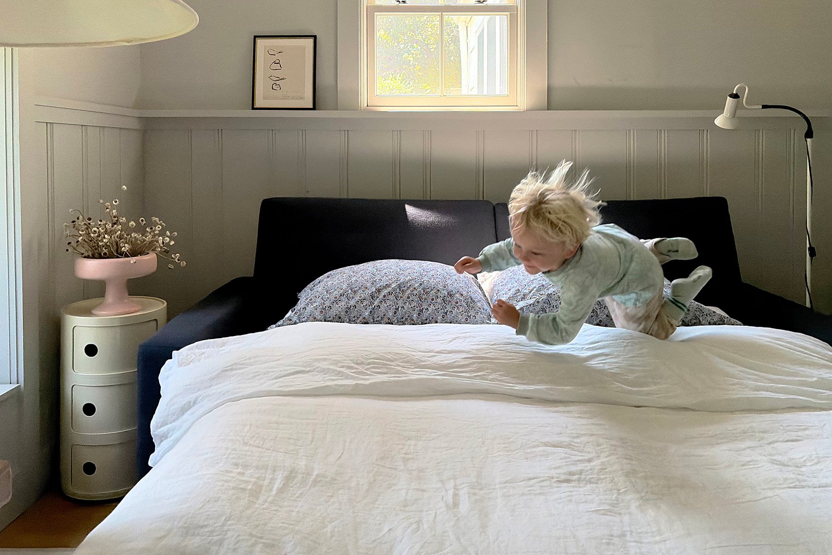 small boy jumping on a bed