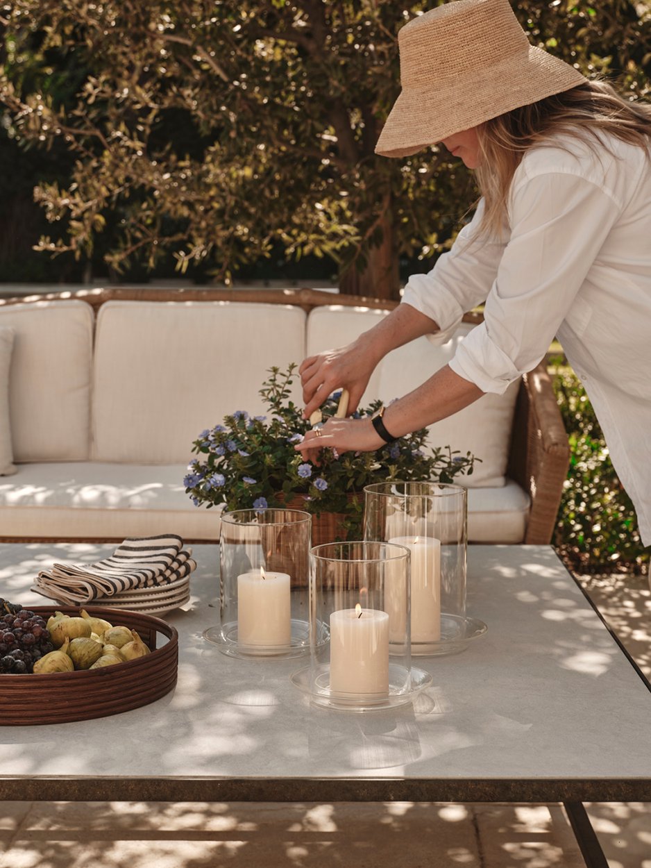 woman clipping plant on outdoor table
