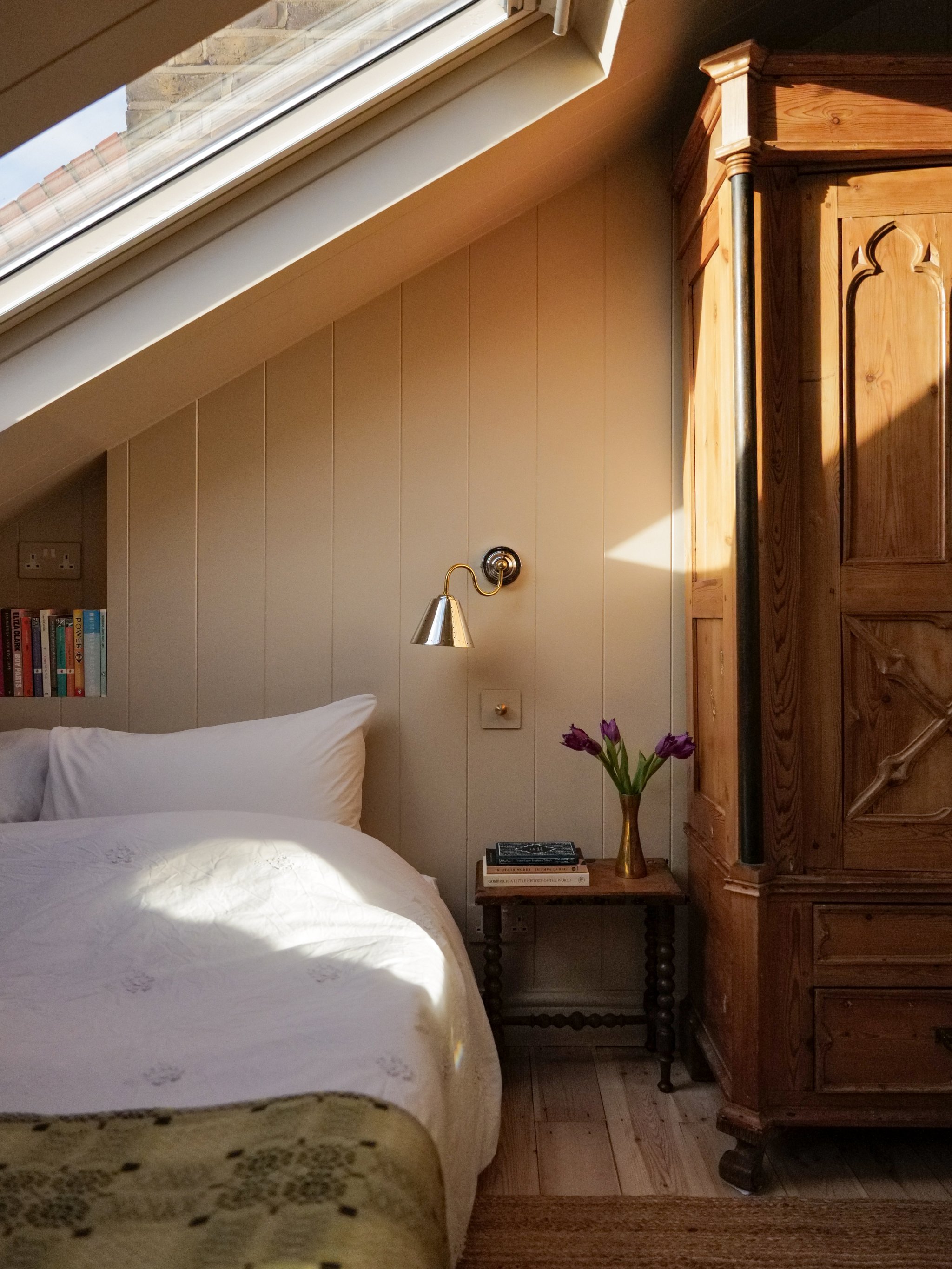 bedroom with conical brass sconce